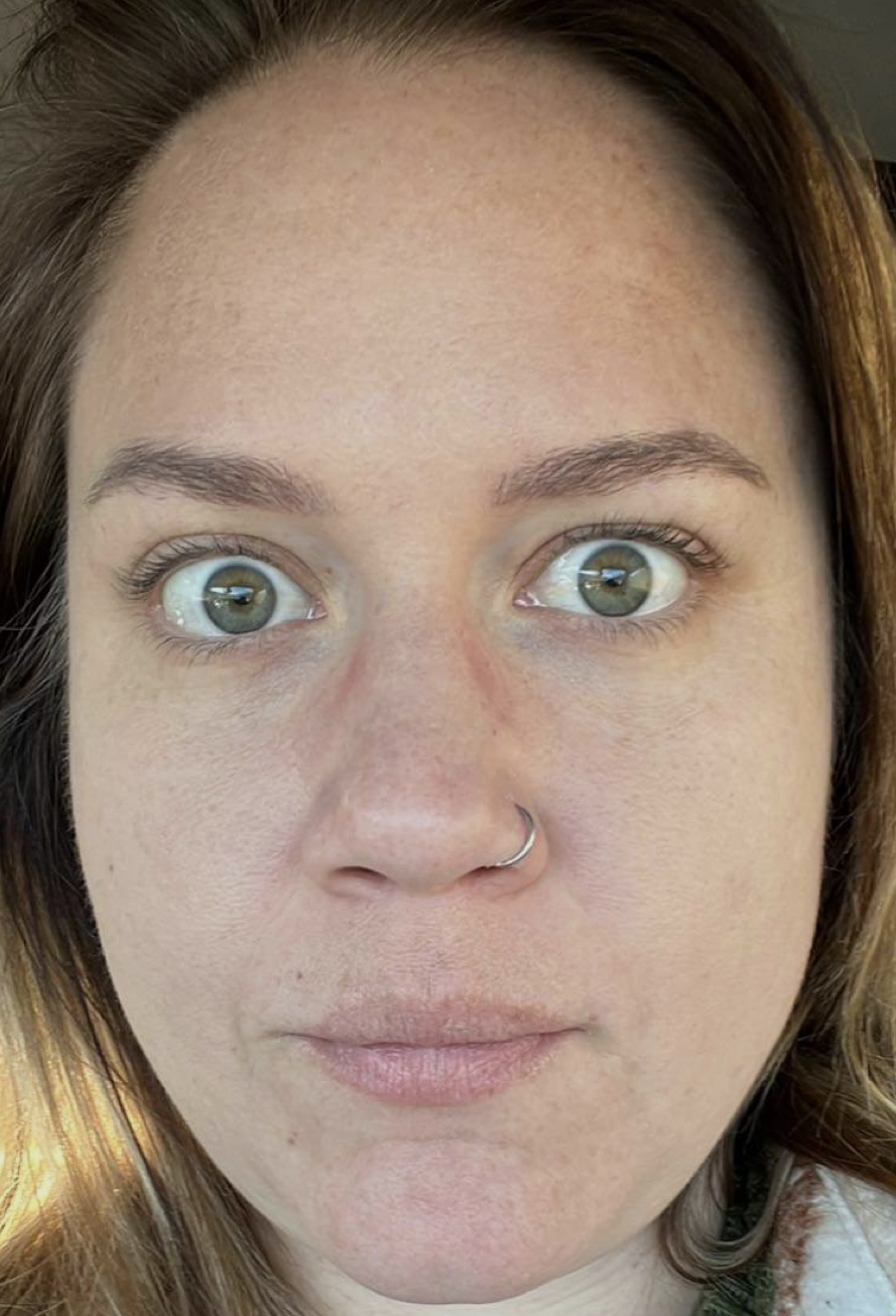 a close up of a woman in glasses looking at the camera