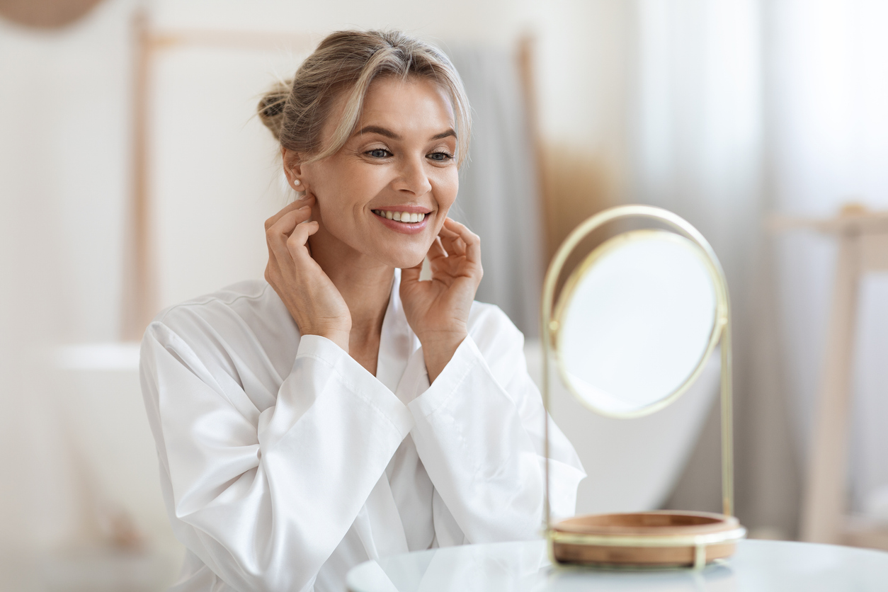 a woman standing in front of a mirror posing for the camera